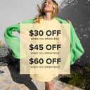 Woman holding a promotional sign with discount information outdoors.